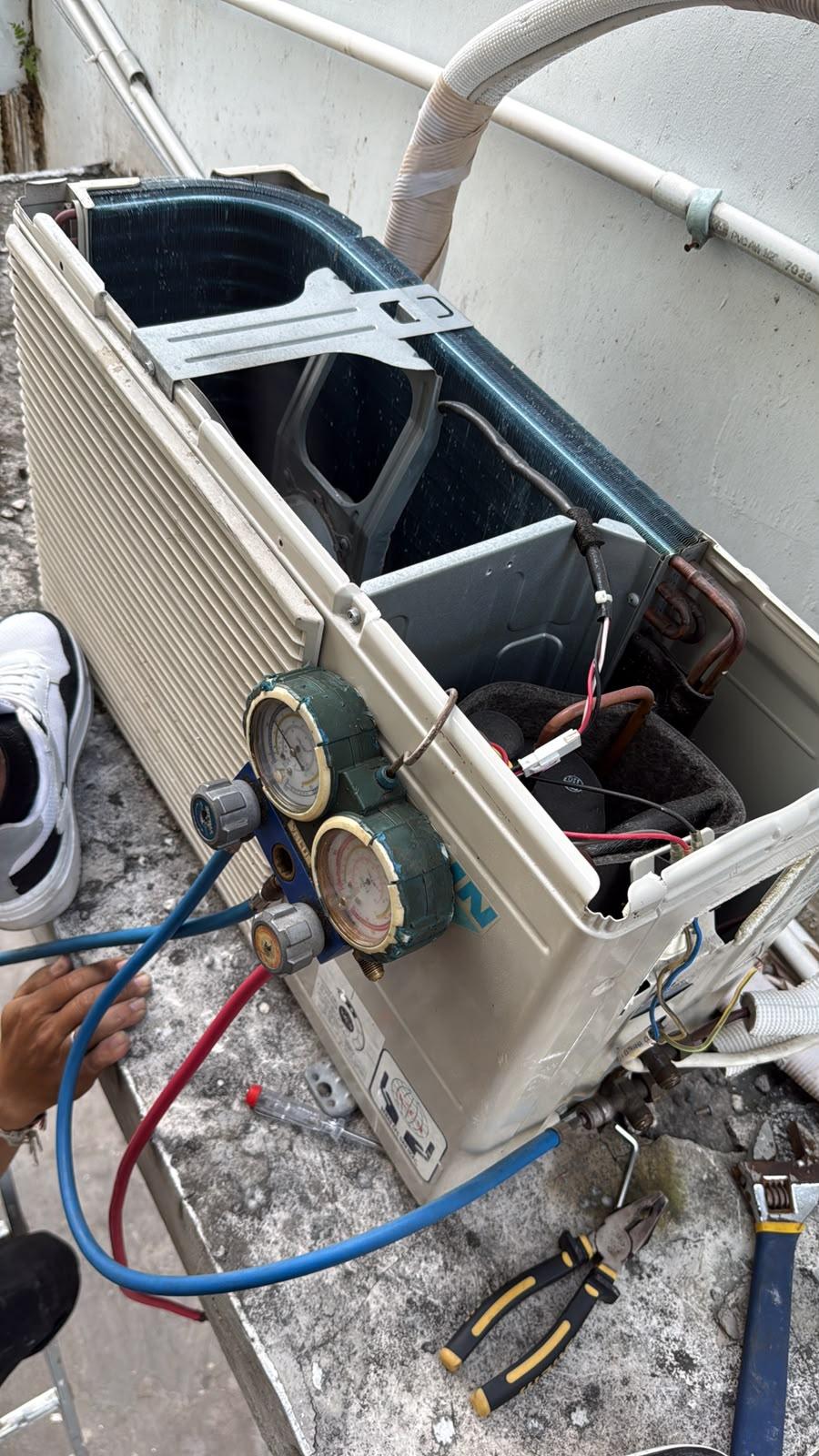 Teknisi membersihkan unit AC indoor
